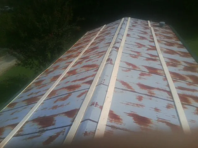 Rusted metal roof panels with new wood purlins before replacement — Storm Damage Roof Repair in Philipsburg by Roofing Brothers
